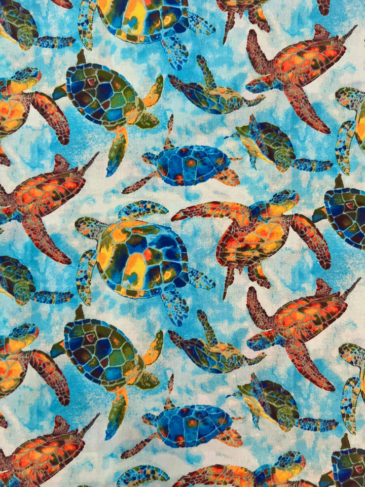 Colorful sea turtle Hawaiian scrub cap fabric close-up showing blue, green and orange watercolor sea turtles on ocean blue, OR World