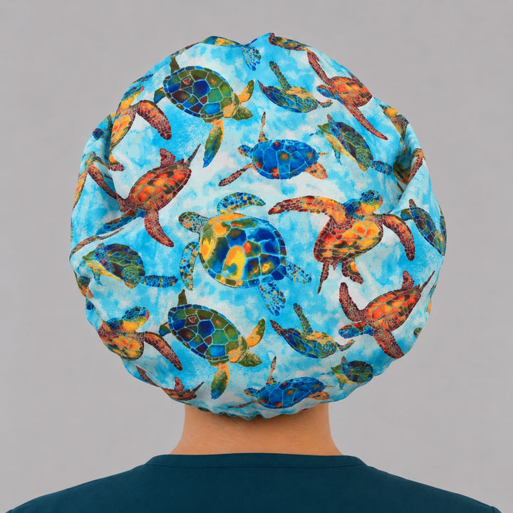 Colorful sea turtle Hawaiian bouffant scrub cap for women, front view, vibrant sea turtles on watercolor ocean blue, handmade tropical nurse hat by OR World