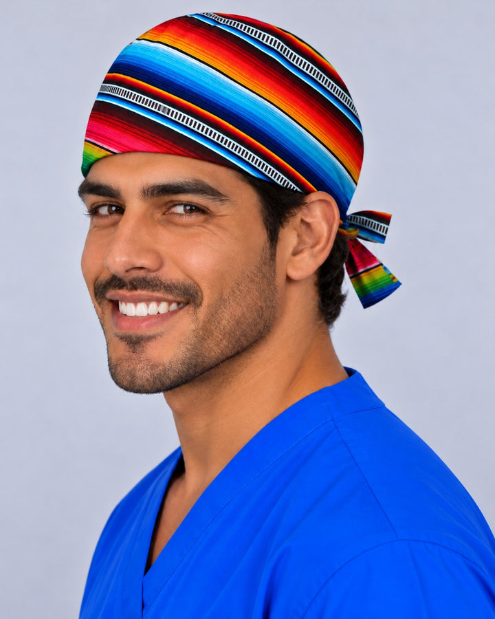 Left side angle of a colorful serape OR cap in 100% cotton, showing turquoise, orange and pink stripes running diagonally to a striped bow at the back