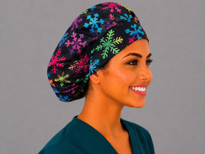 Right side profile of the colorful snowflake bouffant surgical hat — pink, teal and lime snowflakes on black, roomy breathable cotton cap for nurses