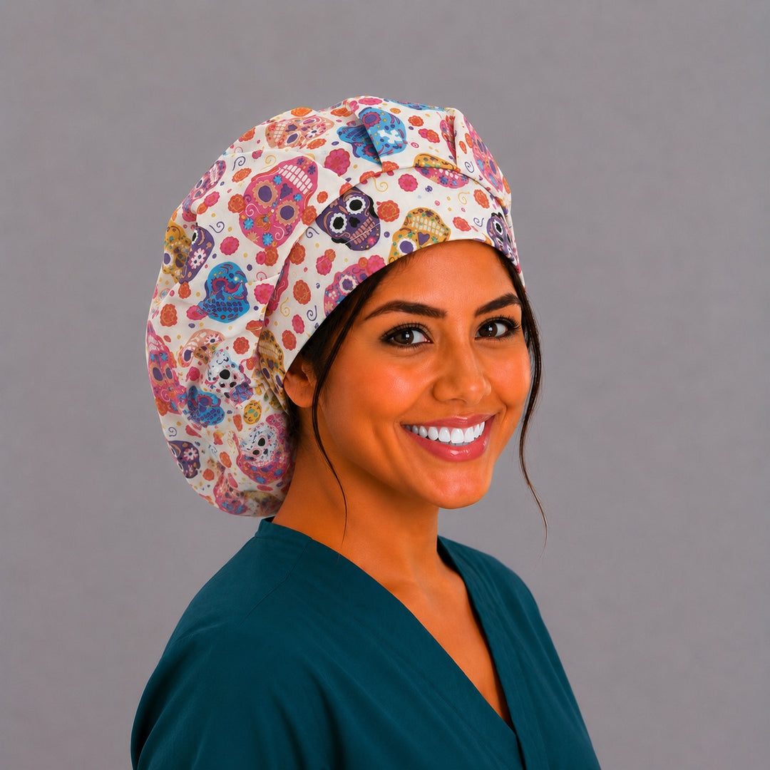 Colorful sugar skull bouffant scrub cap left side profile showing pink purple blue and orange Day of the Dead skulls on cream, women&