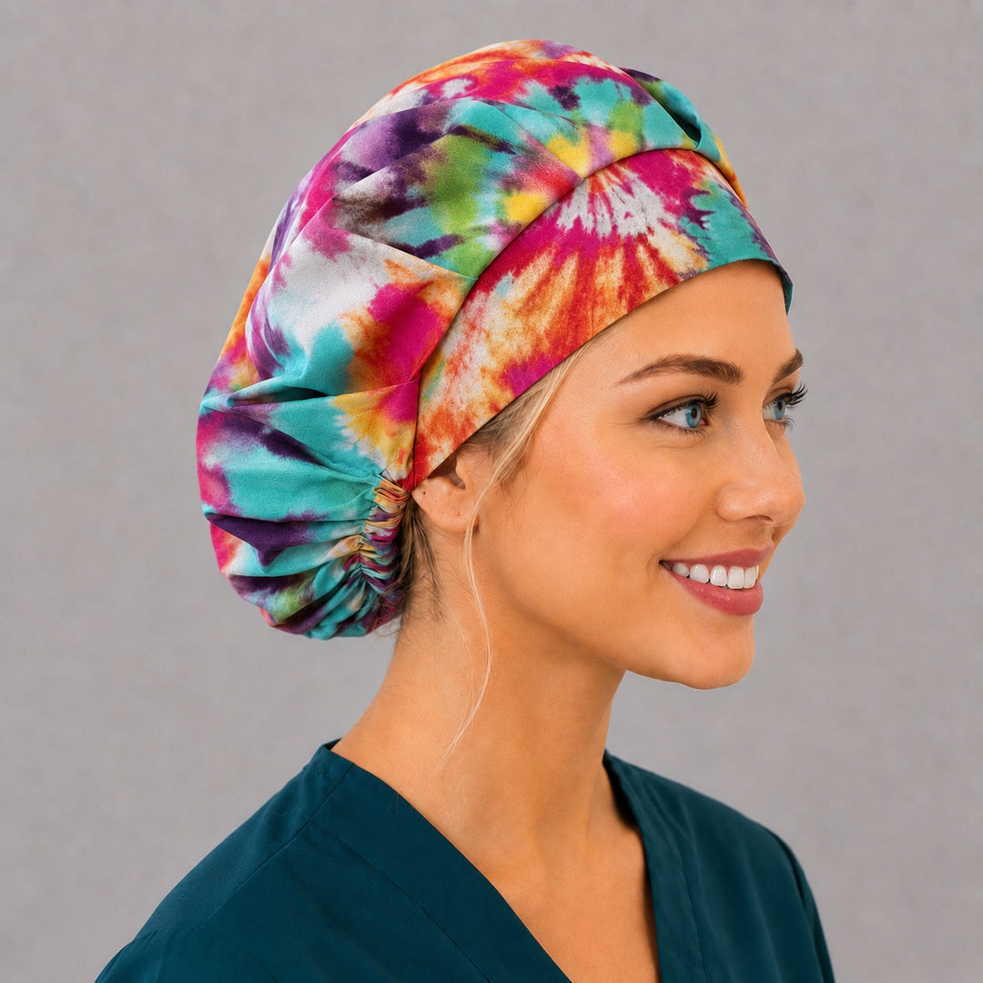 Colorful tie-dye bouffant scrub cap, left angled smiling view — kaleidoscope spiral print for OR nurses and surgical techs