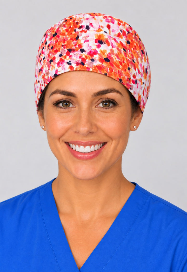 Coral and pink confetti print scrub cap in straight front view, unisex OR hat with clean crown fit