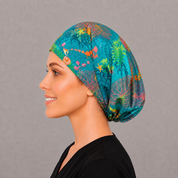 Coral reef Euro scrub cap, right angled smiling view — vivid seahorse and nautilus print for surgical techs and vet teams