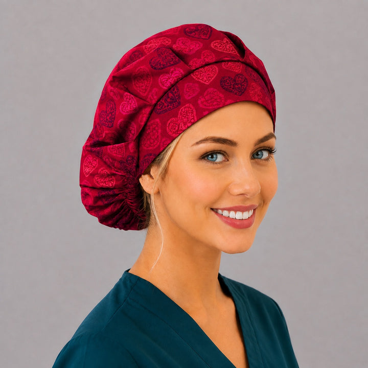 Crimson heart bouffant scrub cap, right angled smiling view — romantic heart print for OR nurses and surgical techs