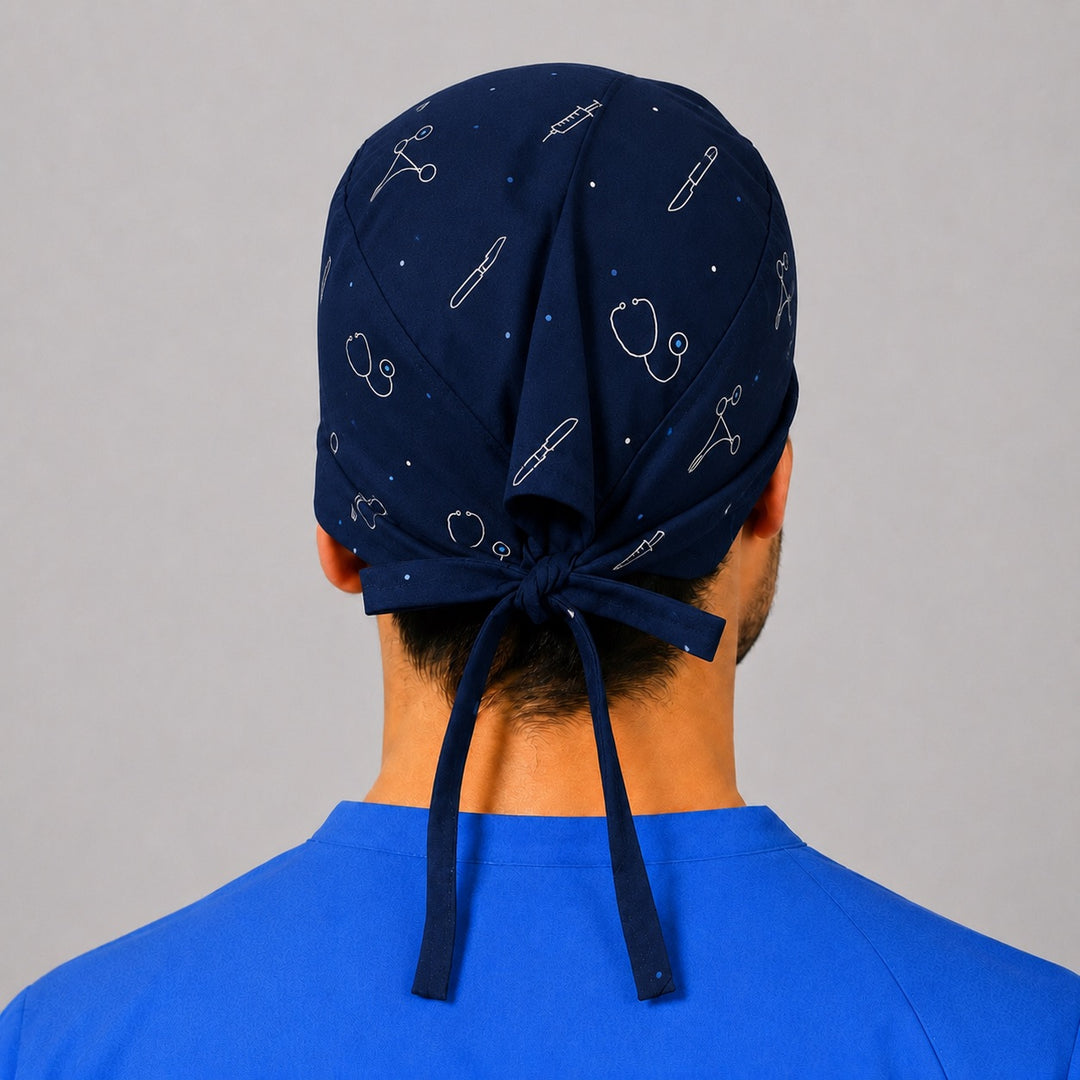 Back view of a custom photo cartoon tie-back scrub cap in navy with a bow-tied closure and scattered medical instrument icons, personalized surgical hat printed by OR World