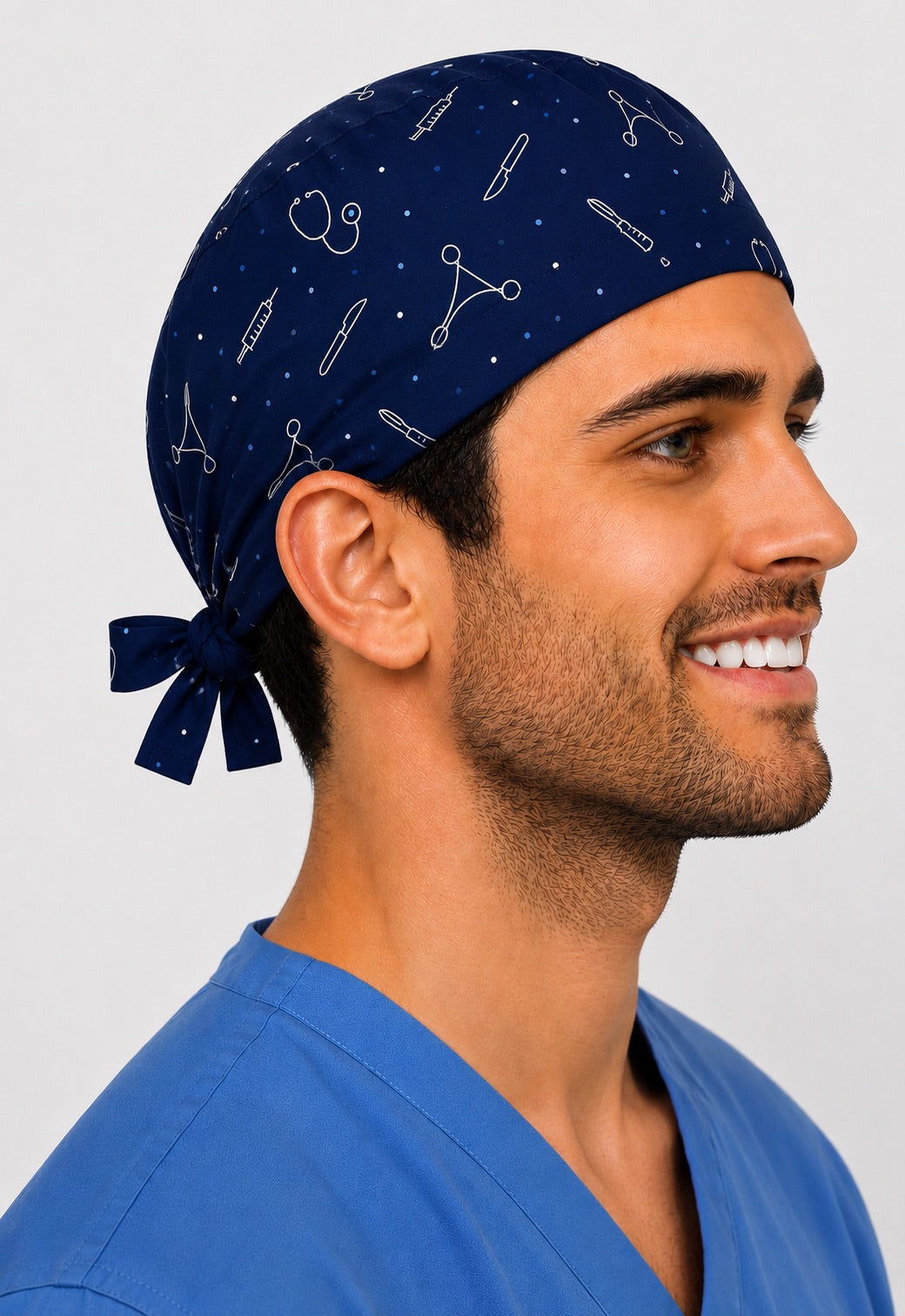 Side profile of a navy custom photo cartoon tie-back scrub cap with scattered white medical line-art icons like scalpel, syringe and stethoscope, personalized men&