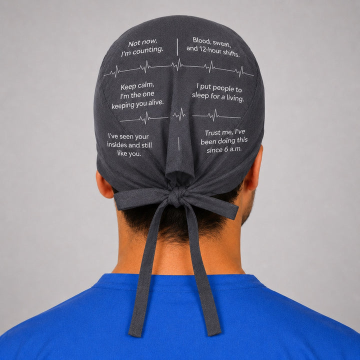 Side profile of custom quote scrub cap in charcoal gray showing tie back closure and heartbeat line, funny personalized medical sayings, your own words custom text surgical hat for men, handmade in USA gift for nurses and surgeons, OR World