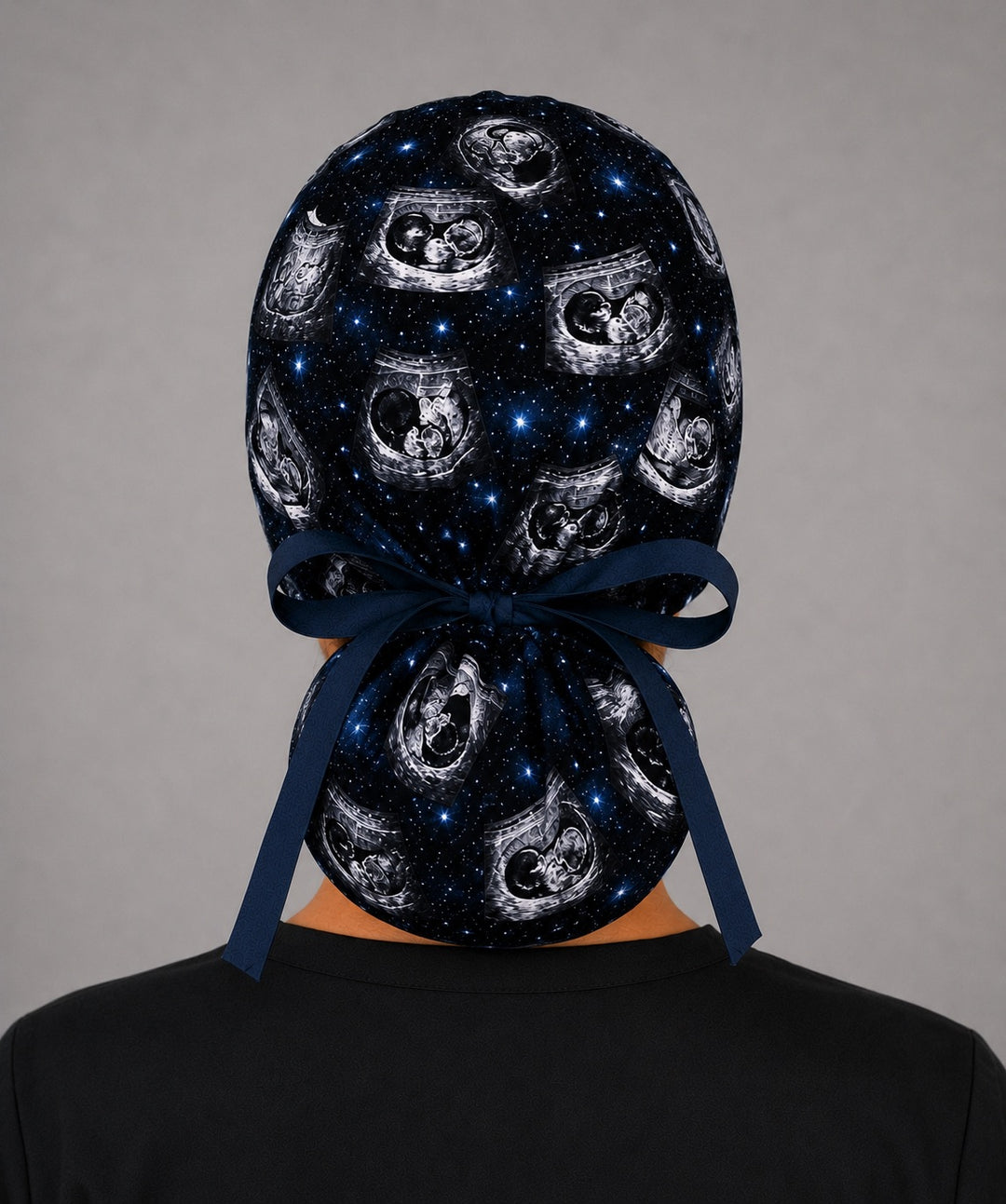 Back view of custom ultrasound ponytail scrub cap with full ponytail pouch and navy tie back closure, personalized galaxy ultrasound print, handmade in USA by OR World.