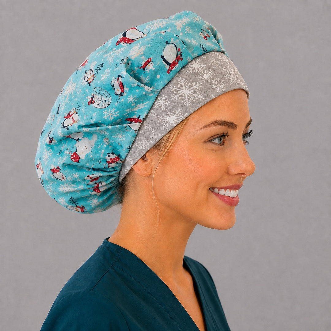 Angled view of the cute penguin and igloo bouffant surgical hat — aqua winter print with snowflake contrast band, roomy breathable cotton cap