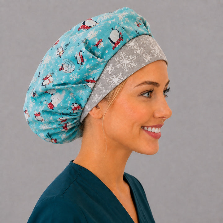 Angled view of the cute penguin and igloo bouffant surgical hat — aqua winter print with snowflake contrast band, roomy breathable cotton cap