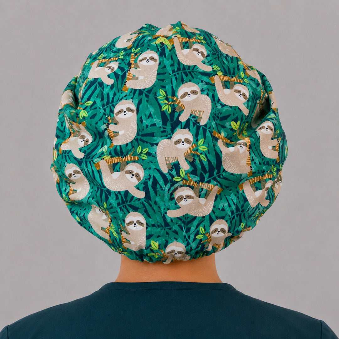 Cute sloth bouffant scrub cap back view showing full print of sloths and tropical jungle leaves on green, OR World animal surgical hat