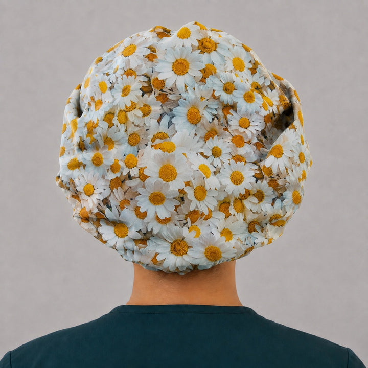 Back view of the daisy bouffant scrub cap — full gathered fit showing white and gold daisies across the whole crown