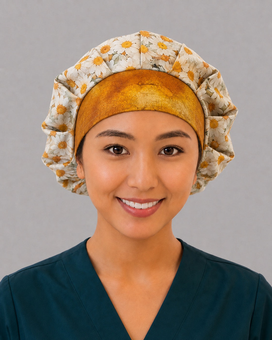 Woman wearing a daisy bouffant scrub cap, front view — white and gold daisy print with antique-gold band, adjustable women&