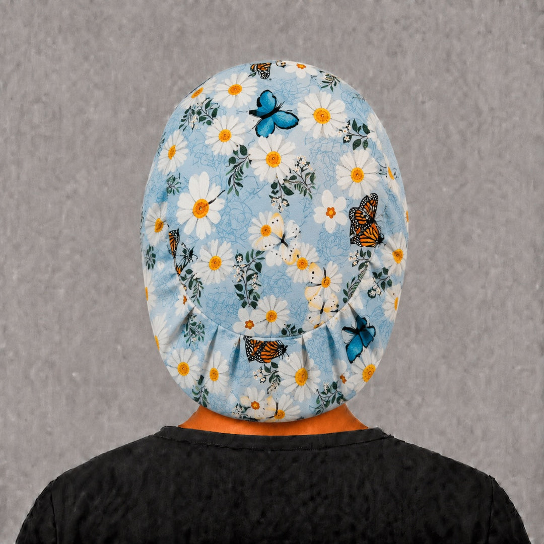 Back view of the daisy butterfly Euro scrub cap — full coverage showing daisies and monarchs across the blue crown