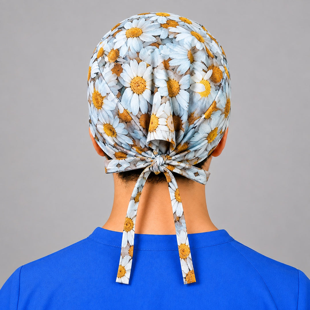 Rear bow with long ties on daisy print scrub hat, adjustable fit shown from behind