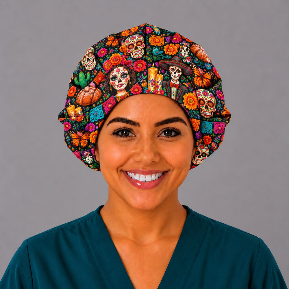 Front view of a Day of the Dead bouffant scrub cap for long hair with colorful calaveras, candles and cempasúchil marigolds on black, worn by a smiling nurse in teal scrubs