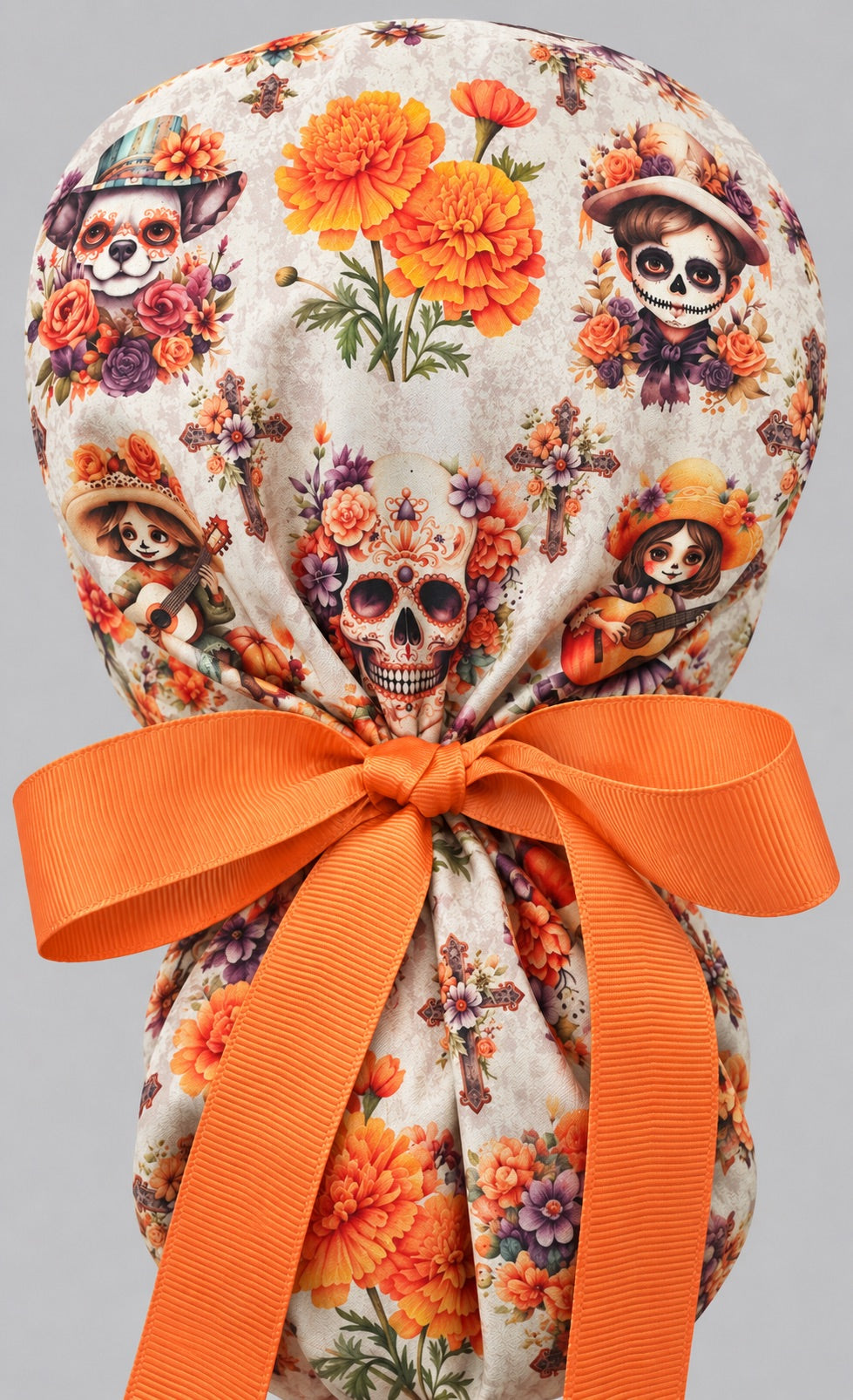 Back of the Day of the Dead ponytail cap with orange grosgrain ribbon tie cinching the pouch, sugar skull and marigold bouquets, gorro quirúrgico mexicano