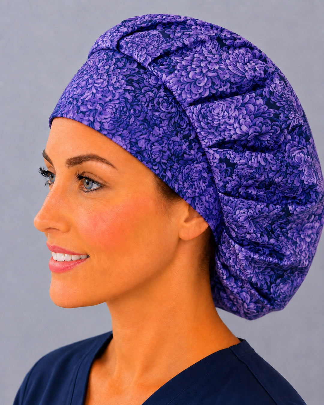 Deep purple floral bouffant scrub cap, left side profile — amethyst and indigo bloom print for OR nurses and surgical techs