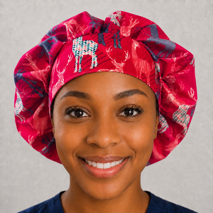 Woman wearing a deer print bouffant scrub cap, front view — blush and teal stags on berry pink, adjustable women&