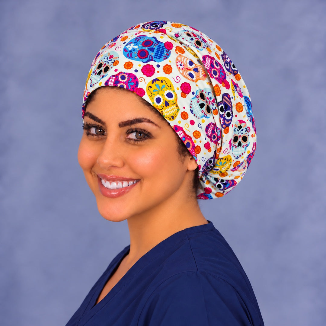 Left three-quarter angle of a smiling healthcare worker in a Día de los Muertos euro cap, with the size of the skulls and marigolds visible at true print scale