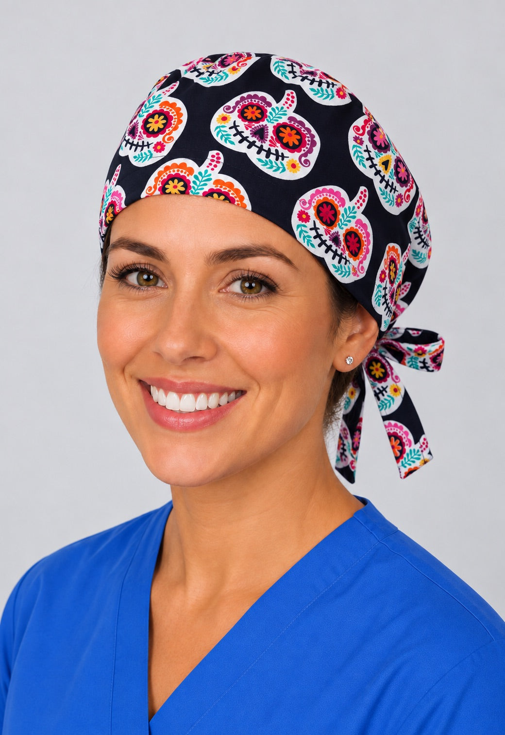 Angled view of Dia de los Muertos surgical cap with floral skull pumpkins, short hair nurse hat