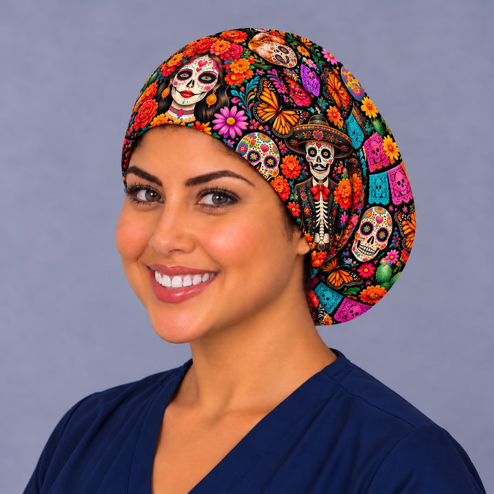 Smiling woman in navy scrubs wearing a Día de Muertos Euro scrub cap with a rose-crowned catrina, charro calavera and papel picado, left angle view of the OR World original print