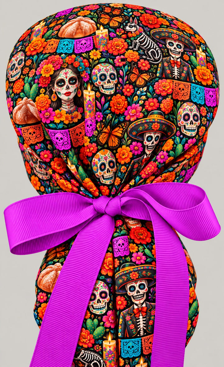 Back view of a Día de Muertos ponytail cap showing the gathered crown and long fuchsia grosgrain bow tails