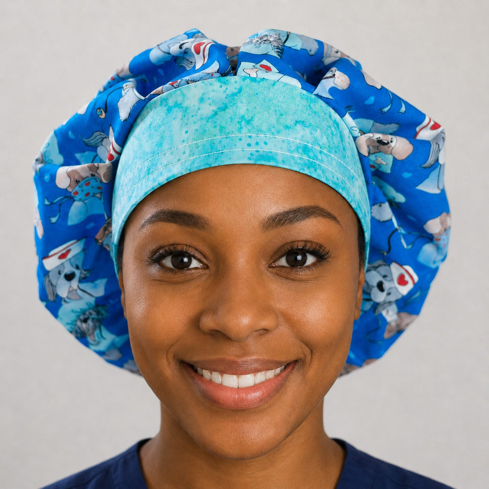 Woman wearing a dog nurse bouffant scrub cap, front view — puppies in scrubs on royal blue with aqua-green band, adjustable women's surgical hat