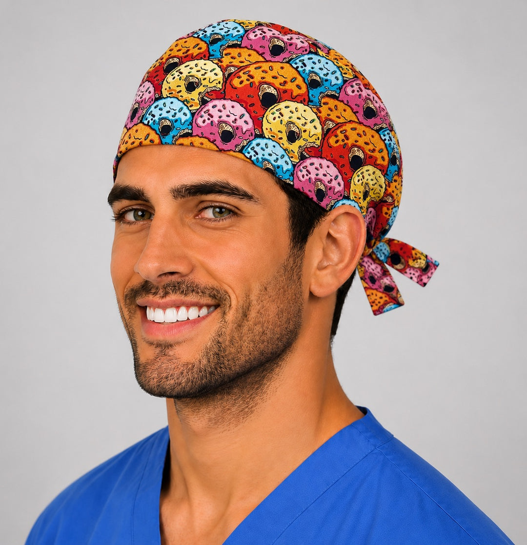 Colorful donut print scrub cap on a smiling male nurse, front three-quarter angle showing the tie-back