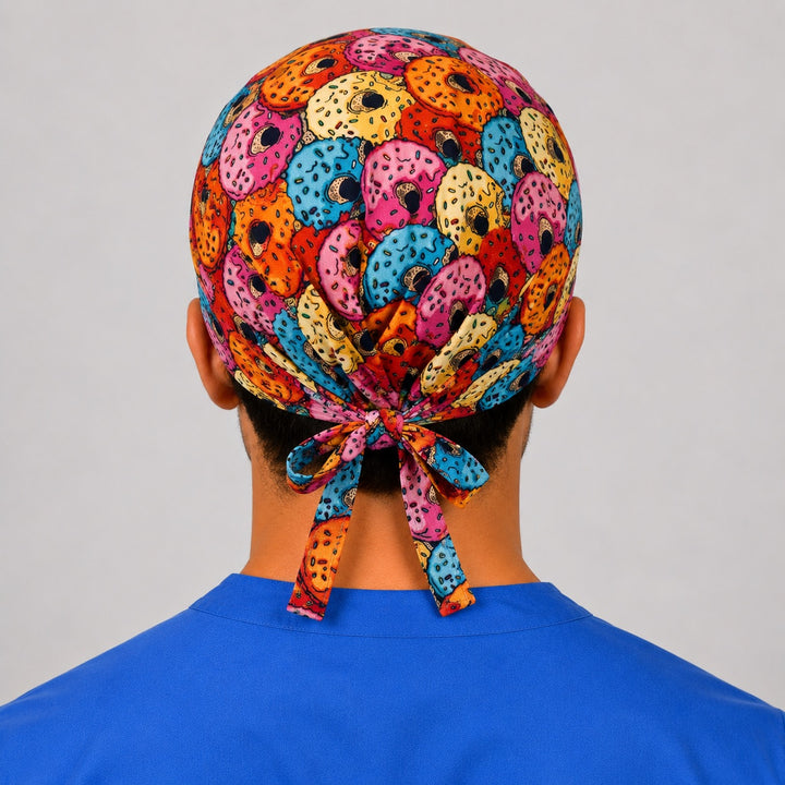 Back view of the colorful donut print tie-back scrub cap showing the bow tie closure and full sprinkle donut print