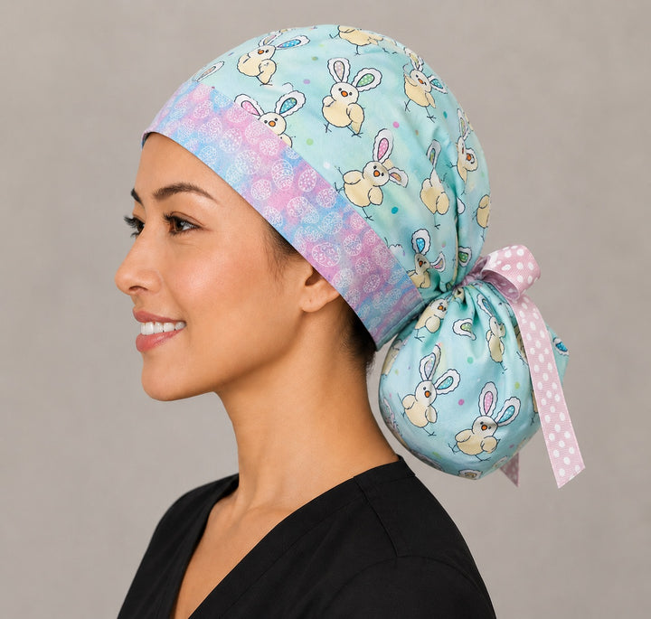 Easter chickens ponytail surgical cap left side profile showing gathered ponytail pouch of bunny-ear chicks on aqua with pink polka-dot ribbon tie