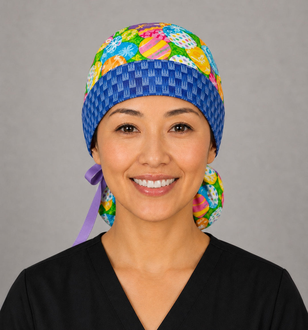 Woman wearing Easter colorful eggs ponytail scrub cap, front view smiling with vibrant decorated Easter eggs and blue bunny band with lavender ribbon tie
