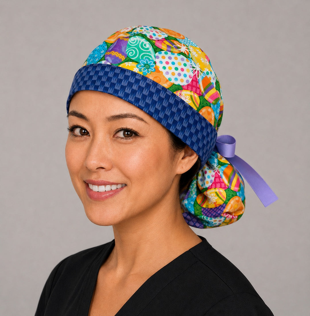 Easter colorful eggs ponytail nurse cap right three-quarter angle on smiling model showing vibrant decorated eggs with blue bunny band and blue ribbon bow