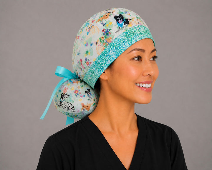 Easter dog ponytail nurse cap left three-quarter front angle on smiling model showing bunny-ear puppies, Easter eggs and flowers with aqua band and aqua ribbon