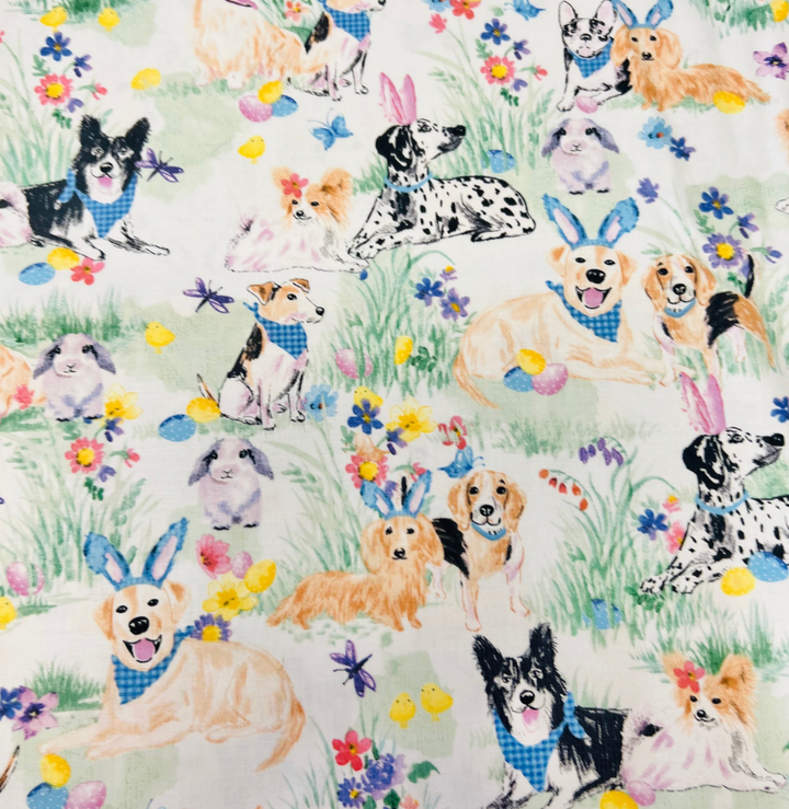 Woman wearing an Easter Dog Euro scrub cap, front view — bunny-eared puppies in spring grass on cream, adjustable surgical hat