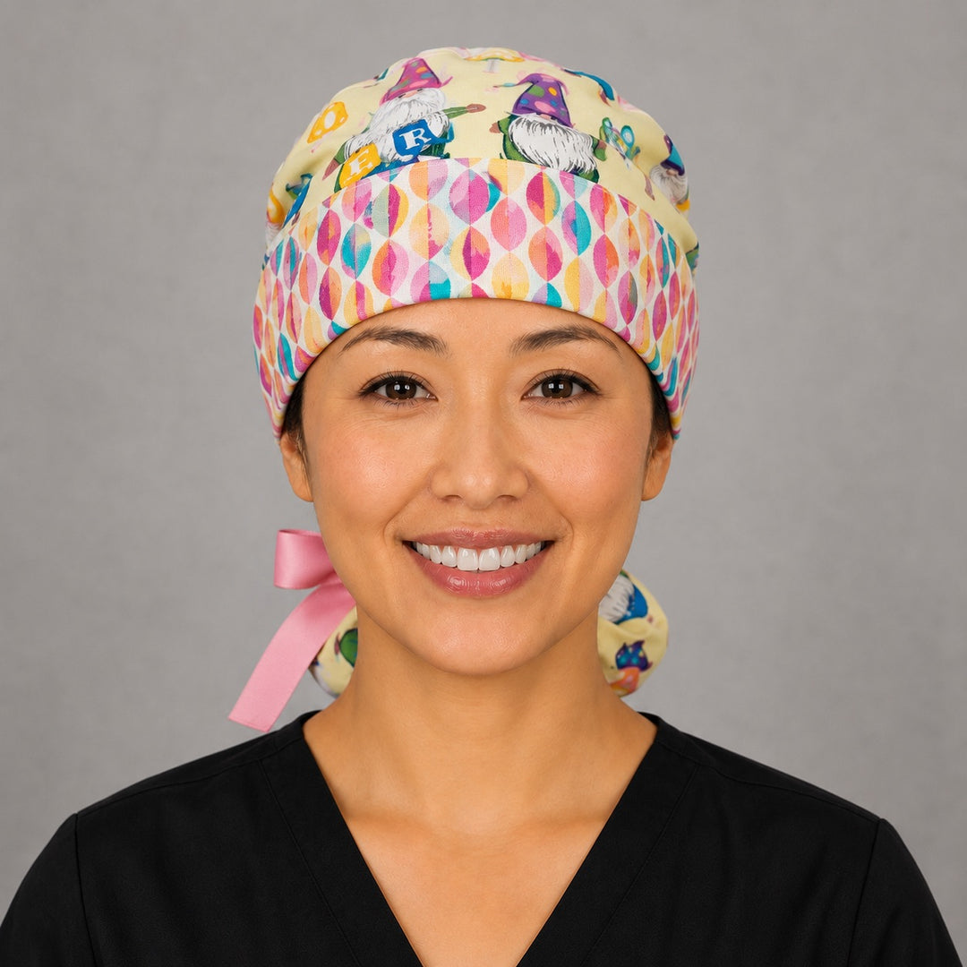 Woman wearing Easter gnomes ponytail scrub cap, front view smiling with pastel gnomes, Easter eggs and baskets on light yellow with egg band and pink ribbon tie