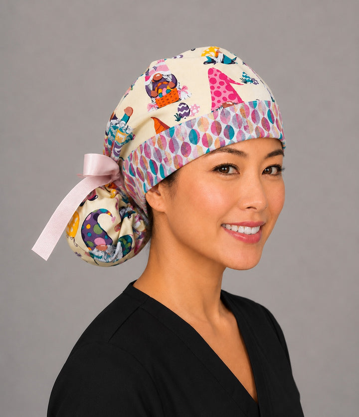 Easter gnomes ponytail scrub cap right three-quarter angle on smiling model showing pastel gnomes, Easter eggs and baskets with egg band and pink ribbon bow
