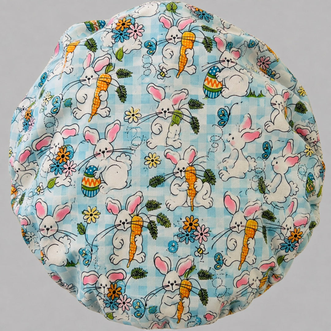Back view of the Easter rabbit bouffant scrub cap — full gathered fit showing bunnies with carrots, eggs and butterflies on aqua gingham