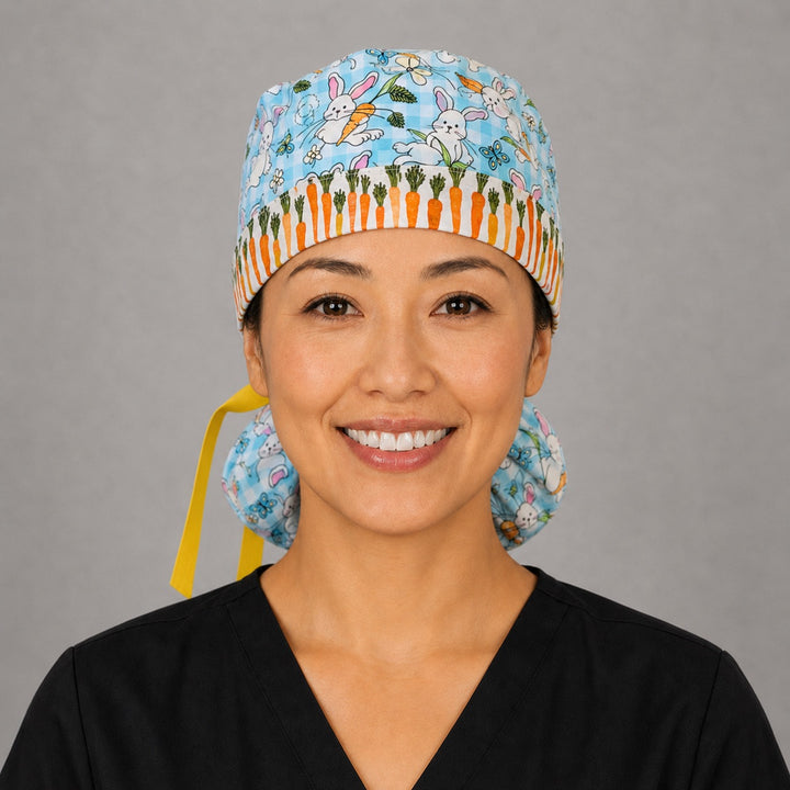 Easter rabbits and carrots ponytail scrub cap front view on smiling model showing carrot band close-up with bunnies and eggs on aqua gingham and yellow ribbon