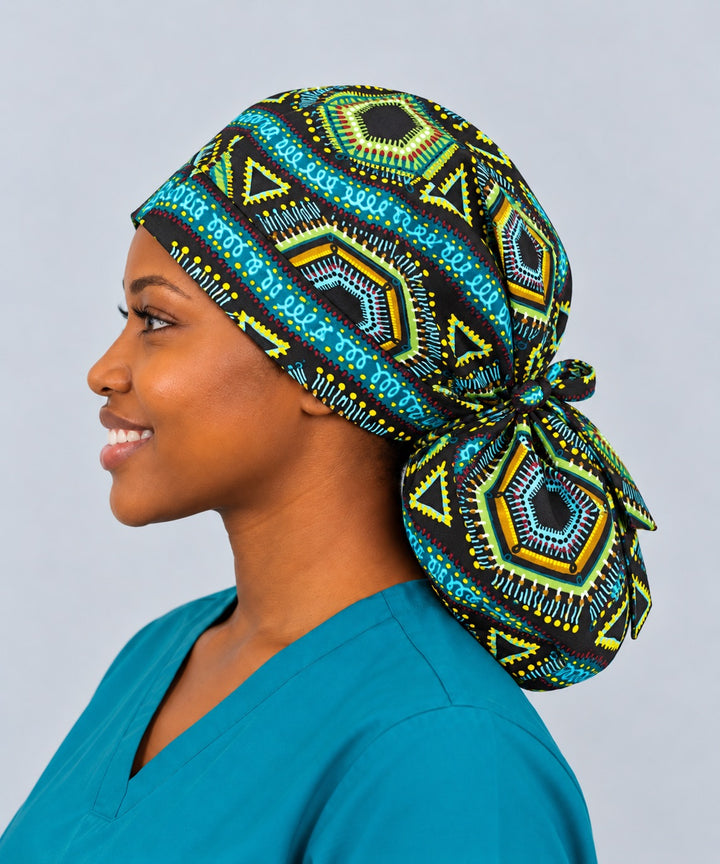 Right side profile of an extra-large Ankara ponytail surgical hat, showing the oversized rounded pouch gathered with a fabric bow at the nape