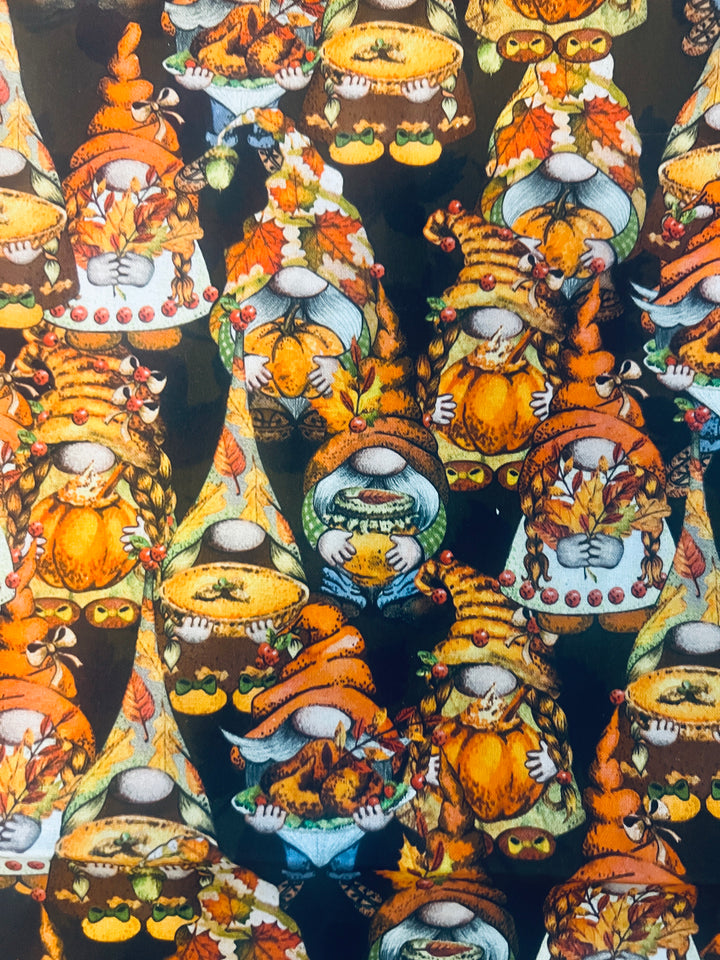 Fabric detail of the fall gnome scrub cap — close-up of pumpkin, pie and turkey gnomes on black cotton