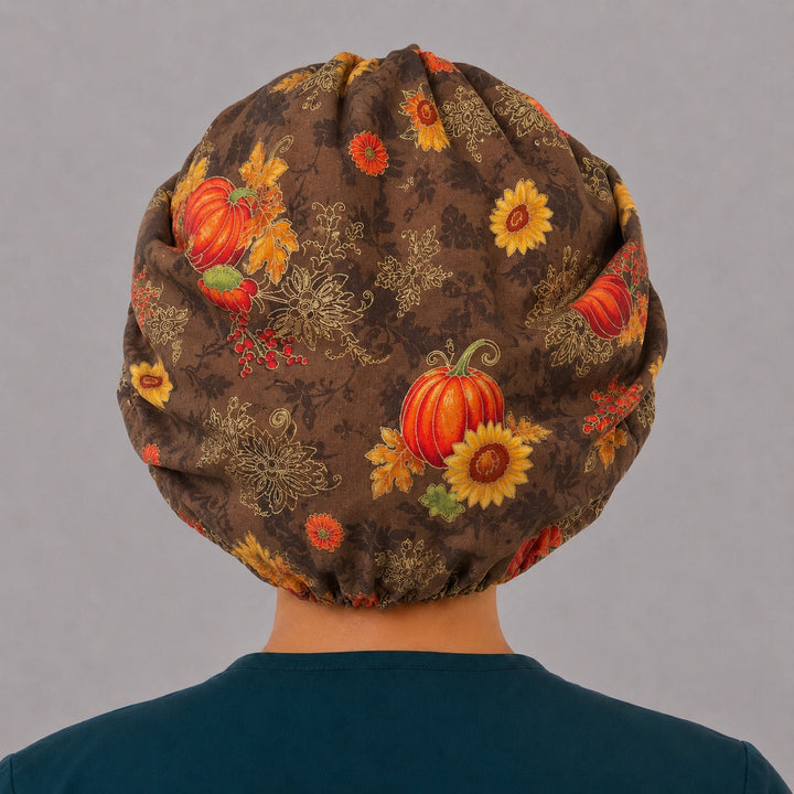 Back view of the fall harvest bouffant scrub cap — full gathered coverage showing pumpkins, sunflowers and berries across the brown crown