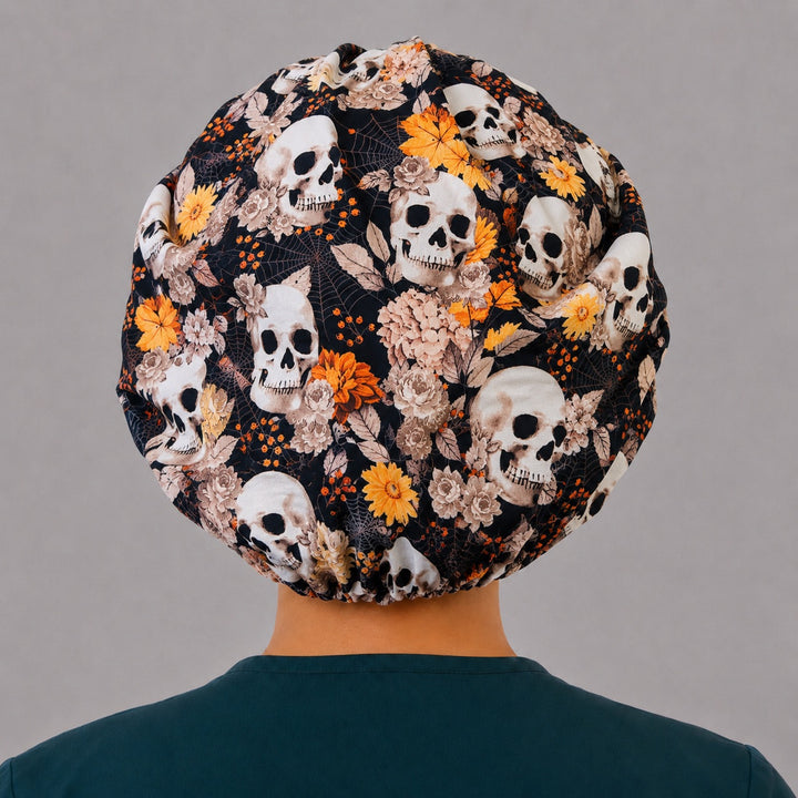 Back view of the fall skull bouffant scrub cap — skulls, sunflowers, roses and spiderwebs across the full black crown