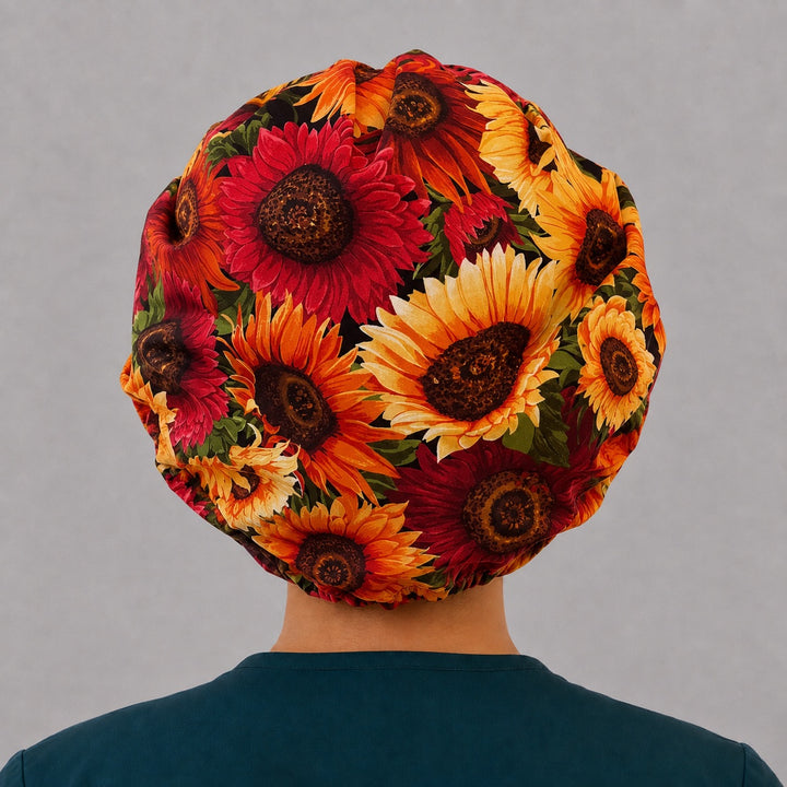 Back view of the fall sunflower bouffant scrub cap — full gathered fit showing oversized gold, orange and crimson sunflowers