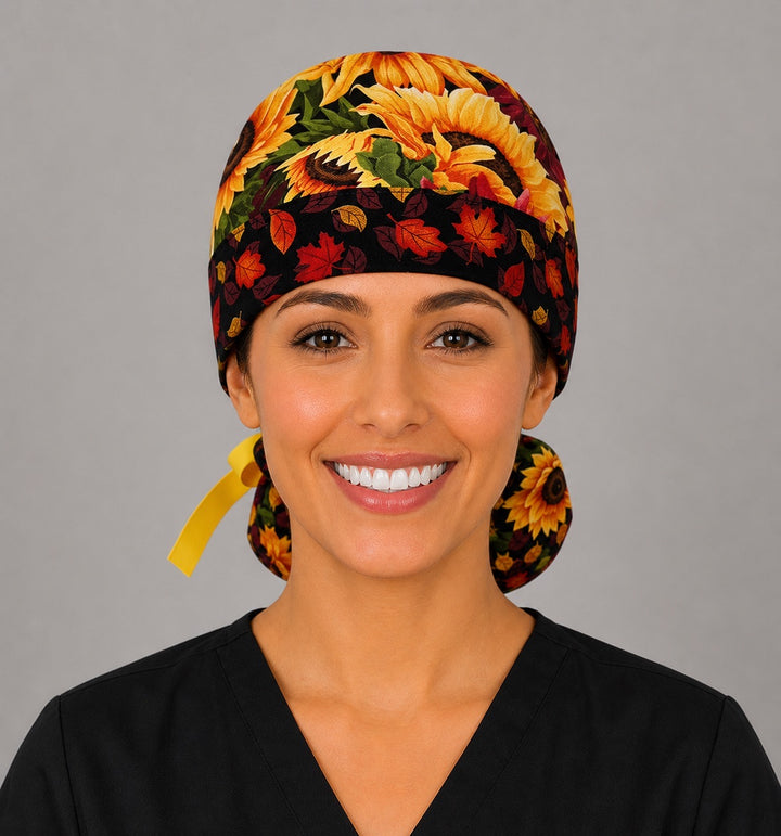Fall sunflower ponytail scrub cap back view close-up showing gathered pouch full of golden, orange and burgundy sunflowers with yellow grosgrain ribbon bow