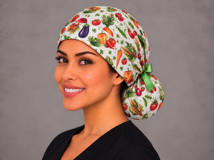 Three-quarter angle of a smiling healthcare worker in a farmers market ponytail cap, with carrots and tomatoes shown at true print scale