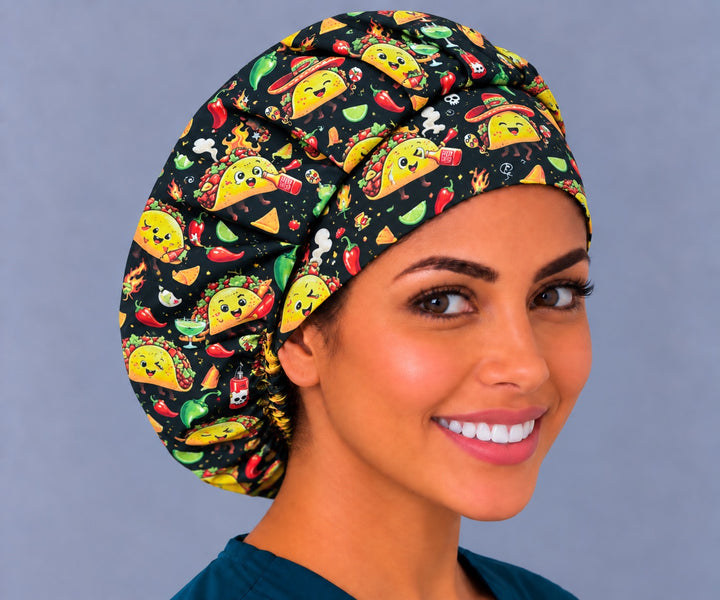 Woman wearing a fiesta taco bouffant scrub cap, front view — dancing tacos, chili peppers and limes on black, adjustable women&