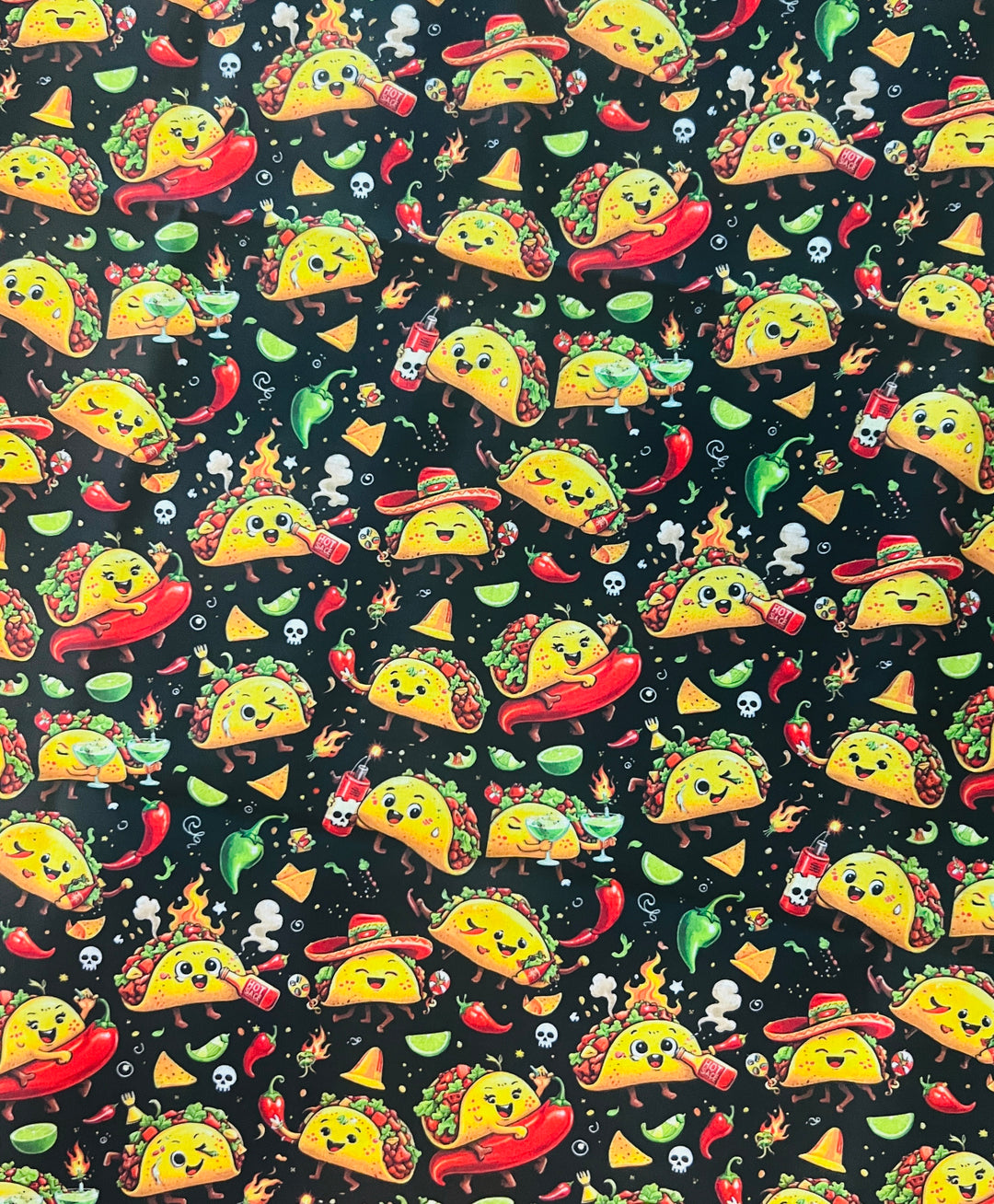 Fabric detail of the fiesta taco scrub cap — close-up of dancing tacos, chili peppers, limes and hot sauce on black cotton