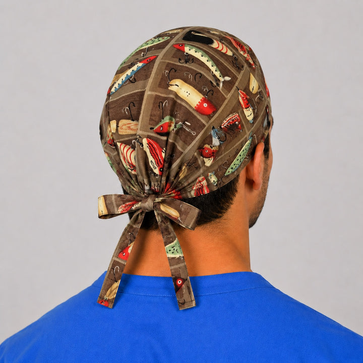 Back view of the fishing tackle tie-back scrub cap showing the bow tie closure and full lure print